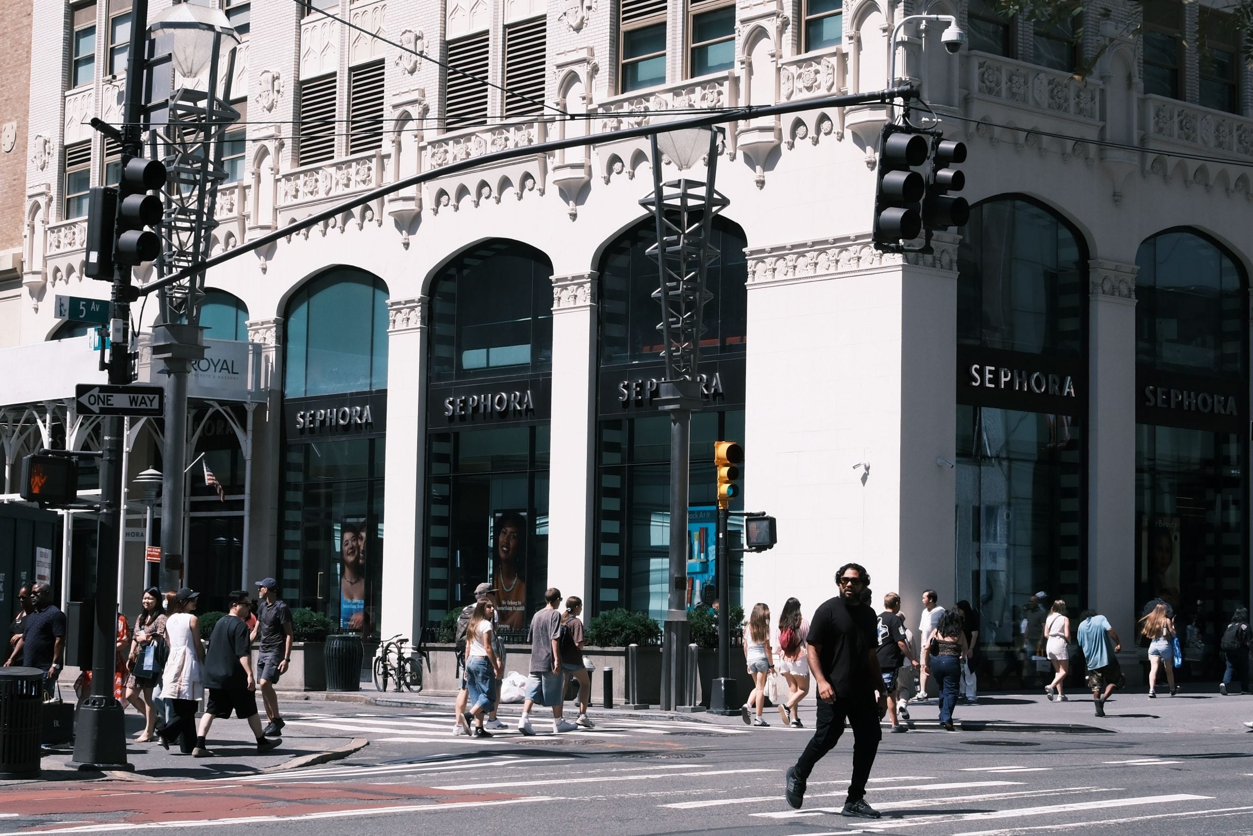 A lively city scene showcasing a Sephora storefront with pedestrians crossing the street.